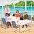 People in an office discussing around a table, with a seaside destination image in the background, representing digital document management in the tourism sector.